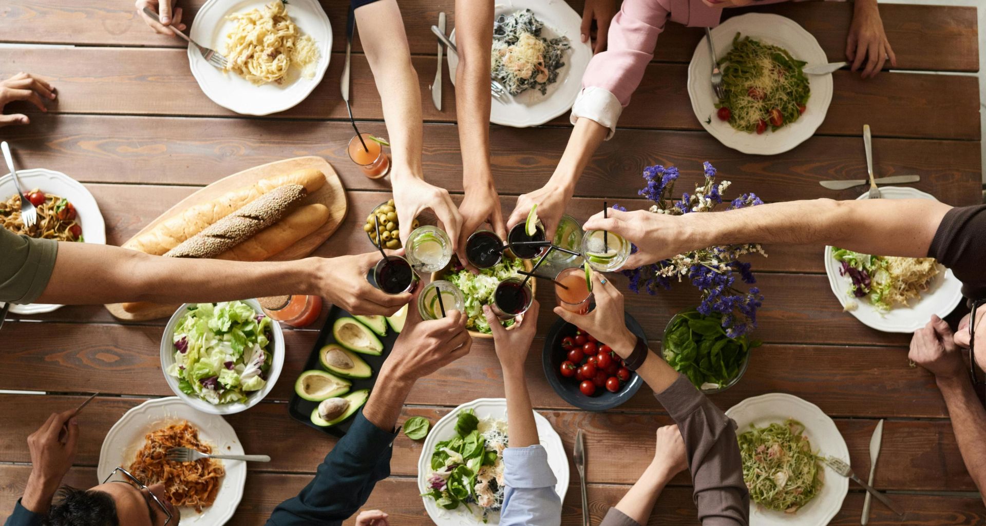 A vibrant group cheers over a delicious meal, showcasing friendship and togetherness.